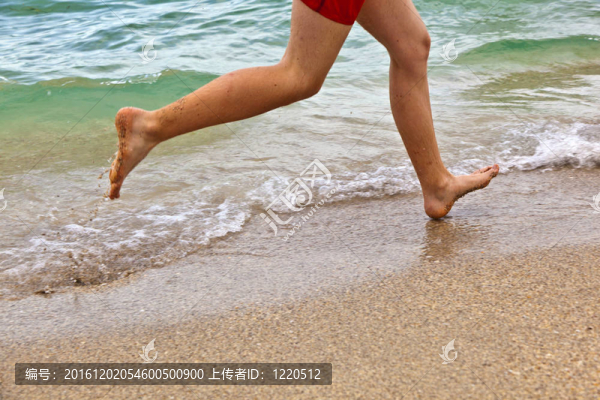 沿著海灘跑步的男孩的腳