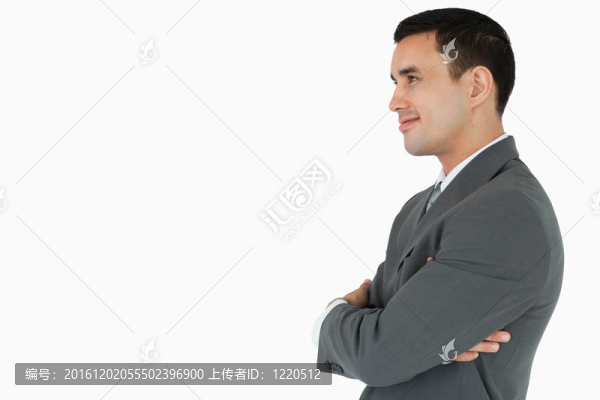 自信的商人用雙臂折疊的側面