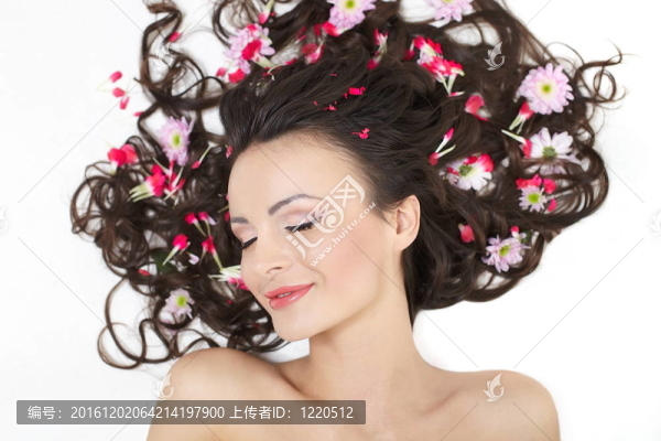 漂亮女孩躺在明亮的紅色花朵在她的頭發(fā)明亮的化妝孤立白色