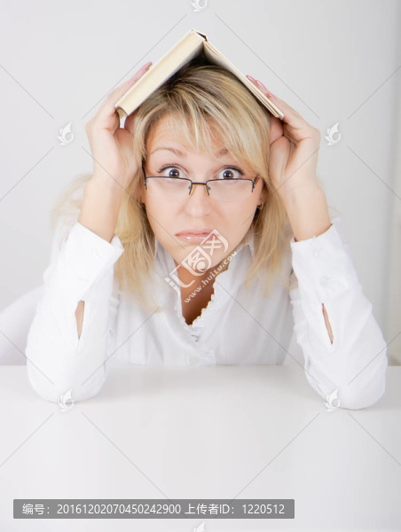 戴眼鏡的女孩藏在一本書下面