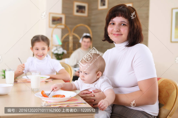 一個(gè)年輕的母親在家喂她的嬰兒