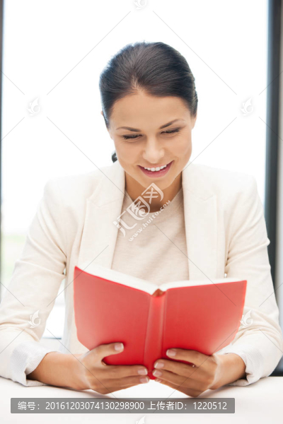 幸福和微笑的女人帶著書