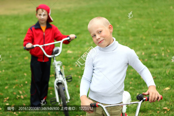 在綠色公園里騎自行車的男孩