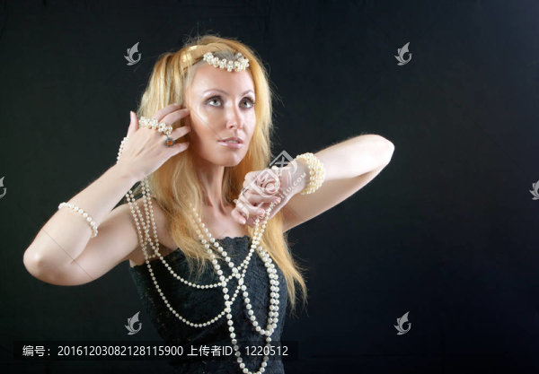 美麗的年輕金發(fā)女子長(zhǎng)頭發(fā)和珍珠珠在黑暗的背景。