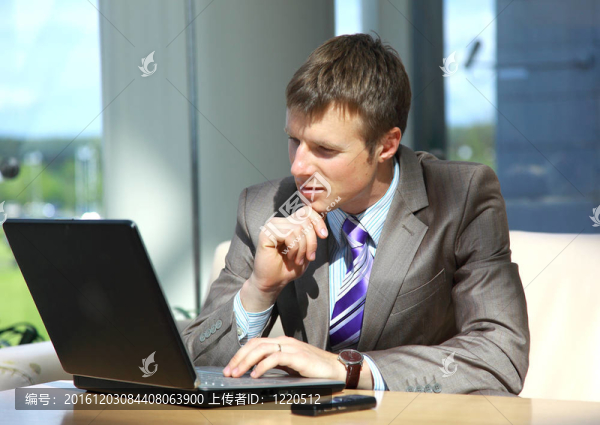 在辦公大廳工作的筆記本電腦生意人