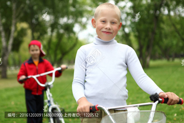 在綠色公園里騎自行車的男孩