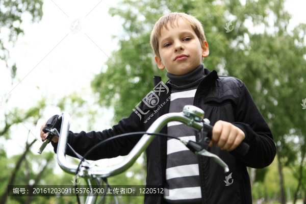 在綠色公園里騎自行車的男孩