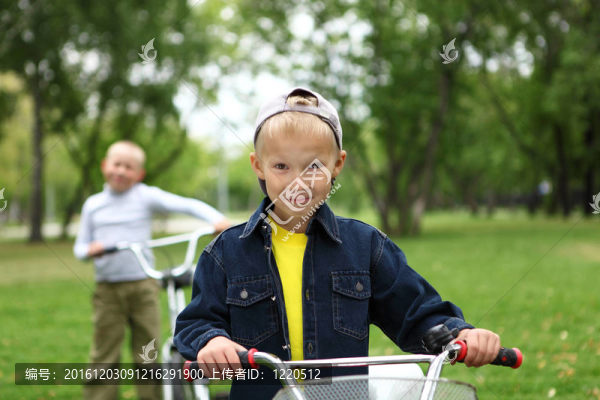 在綠色公園里騎自行車的男孩