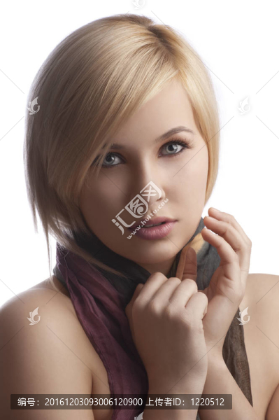 金發(fā)碧眼的年輕女子在一幅特寫肖像中穿著一件秋天的彩色圍巾看著相機在白色背景上孤立