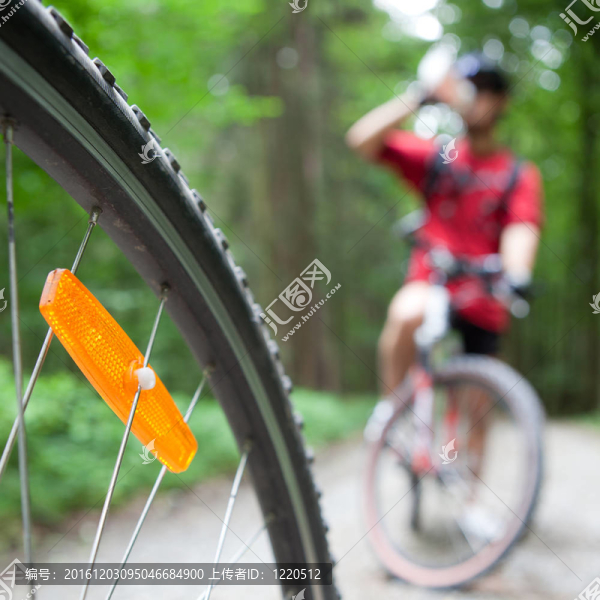 在一個森林的車友在森林自行車步道山地自行車（淺景深；在前景的自行車輪焦點(diǎn)）