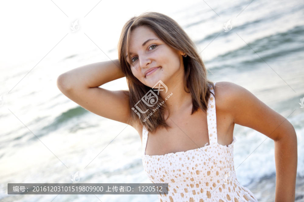 站在海灘上的漂亮的年輕女人