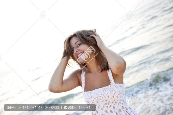 站在海灘上的漂亮的年輕女人