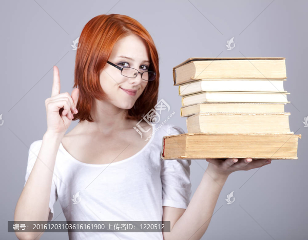 紅頭發(fā)的微笑的女商人把書在手。