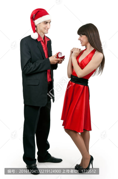在Santa戴帽子的男人給女人一枚戒指