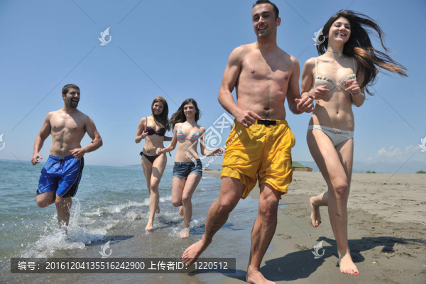 快樂人團體在海灘上玩樂和跑步