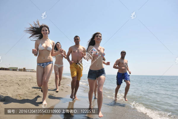 快樂人團體在海灘上玩樂和跑步
