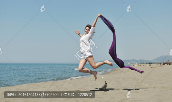 美麗的年輕女子在海灘與圍巾