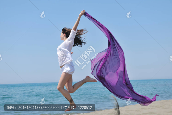 美麗的年輕女子在海灘與圍巾