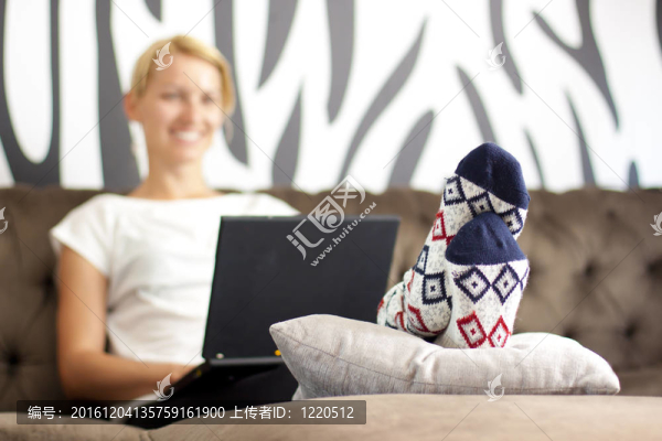 坐在沙發(fā)上的漂亮小姐；使用筆記本電腦