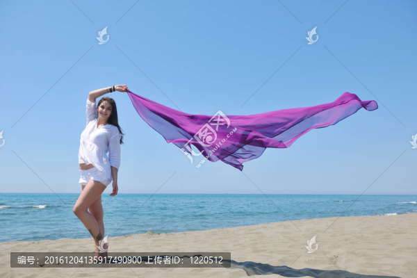 美麗的年輕女子在海灘與圍巾
