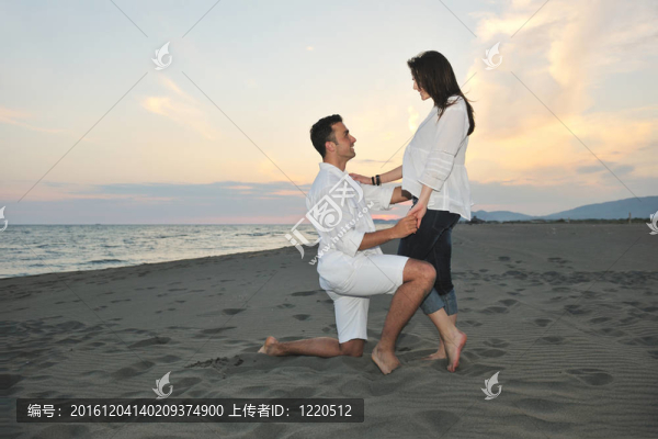 快樂的年輕夫婦在海灘上玩得開心