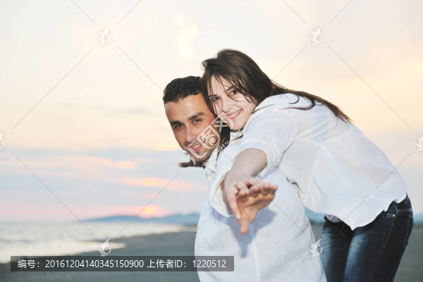 快樂的年輕夫婦在海灘上玩得開心