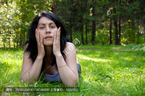 美麗的中年婦女躺在草地上