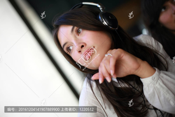 漂亮的年輕女人在耳機(jī)里做白日夢(mèng)