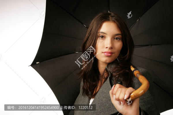 美麗的年輕女子與黑色的雨傘在白色背景