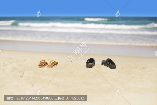 熱帶海灘沙灘上的兩對人字拖鞋。淺景深。