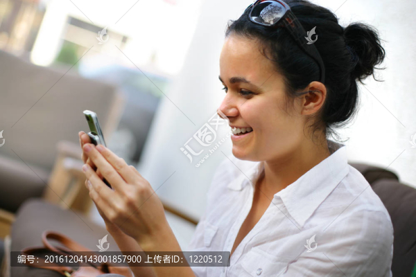一個(gè)漂亮的年輕女人在手機(jī)上讀短信