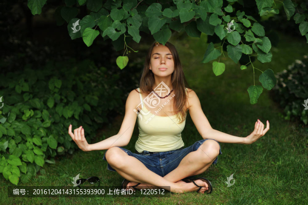 美麗的年輕女子在公園放松瑜伽姿勢