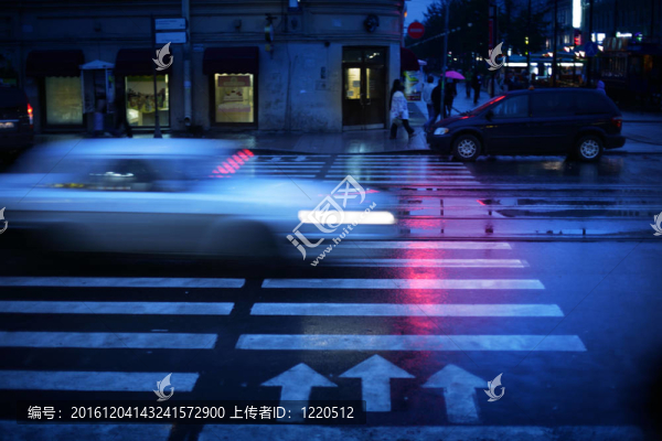 汽車(chē)在夜間穿越人行橫道；運(yùn)動(dòng)模糊。