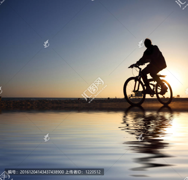 騎自行車的身影騎在日落海灘