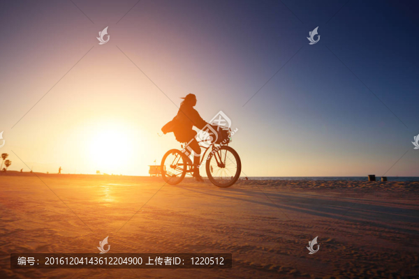 騎自行車(chē)的身影騎在日落海灘
