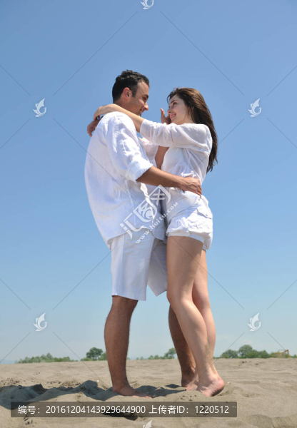 快樂的年輕夫婦在海灘上玩得開心