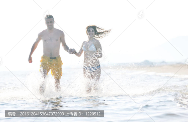 快樂的年輕情侶在海灘上度過浪漫時(shí)光