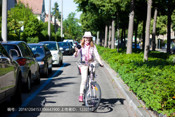 女人騎自行車邊拍照