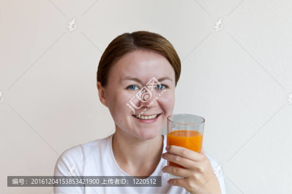 拿著一杯橙汁的女人