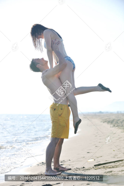 快樂的年輕情侶在海灘上度過浪漫時光