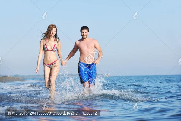 快樂的年輕情侶在海灘上度過浪漫時光