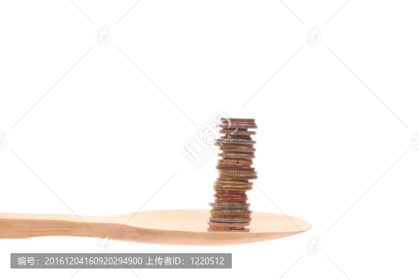 在白色背景上的木制勺子上的錢