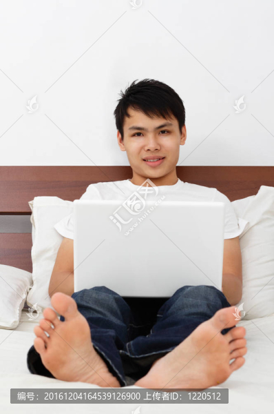 床上有筆記本電腦的人