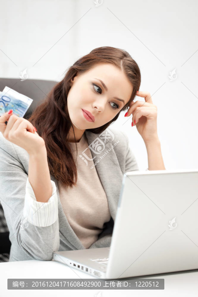 憂郁的女人與計算機和歐元現(xiàn)金