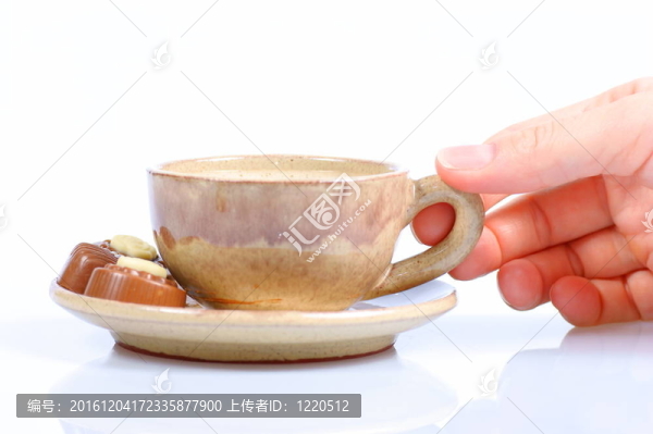 果仁巧克力；杯；黑咖啡和女性手上白色