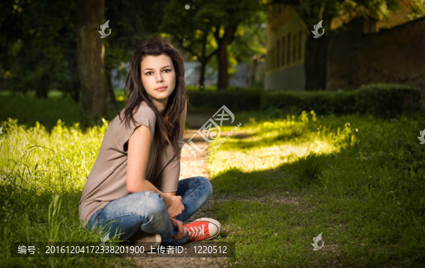 美麗的年輕女人坐在公園里悠閑的肖像。