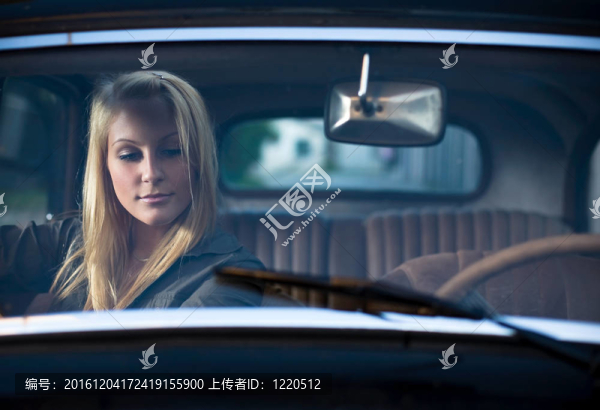 一輛老式轎車中一位年輕漂亮金發(fā)女郎的畫像。
