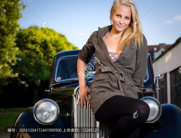 美麗的年輕金發(fā)女孩與黑色老式車。