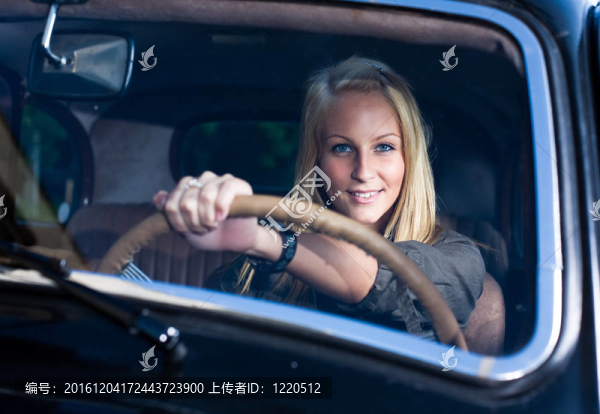 美麗的年輕金發(fā)女孩在黑色老爺車。