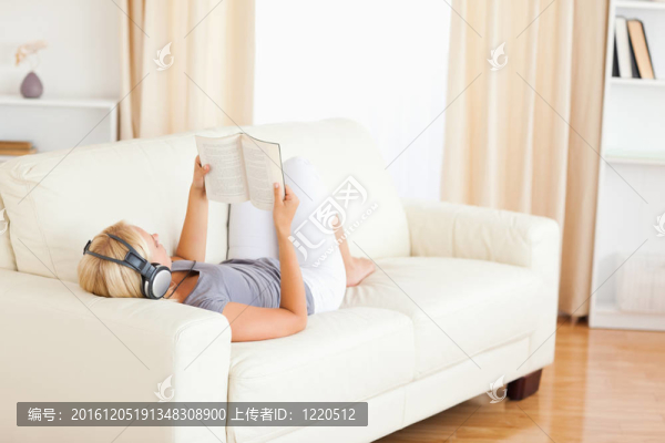 女人一邊看書一邊欣賞音樂